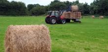 Gathering hay bales from a field